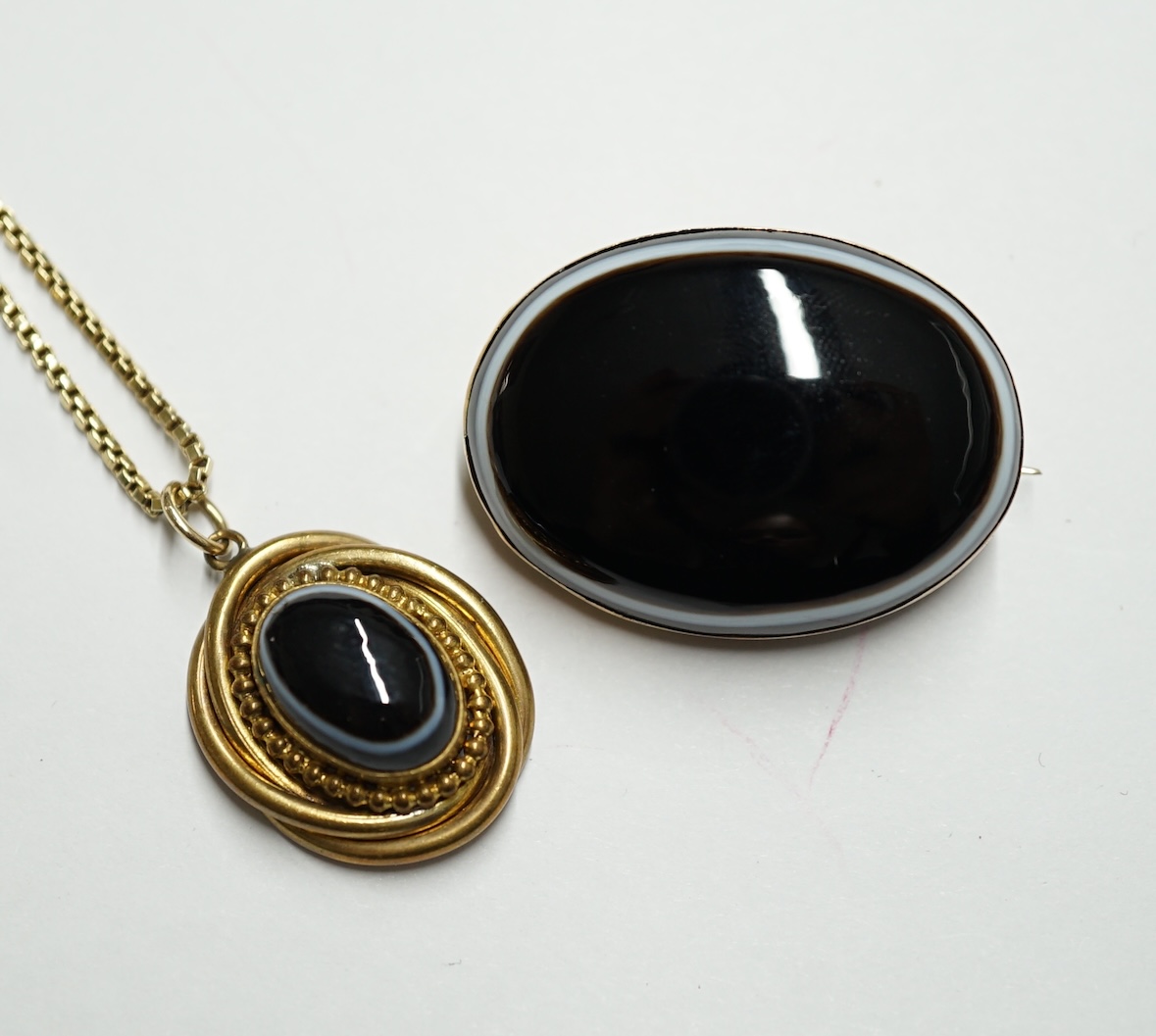 A continental yellow metal box link necklace with oval banded agate set pendant, overall 58cm and a similar brooch. Condition - fair